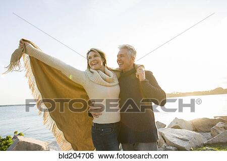 Caucasian couple walking by lake View Large Photo Image Stock Photograph - Caucasian couple walking by lake. Fotosearch