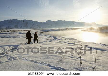 Caucasian couple walking in snowy landscape View Large Photo Image Picture - Caucasian couple walking in snowy landscape. Fotosearch