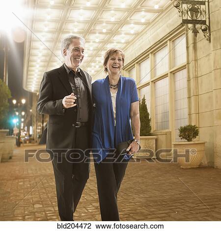 Caucasian couple walking on city street View Large Photo Image Stock Image - Caucasian couple walking on city street. Fotosearch