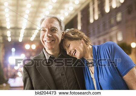 Stock Image - Caucasian couple walking on city street. Fotosearch