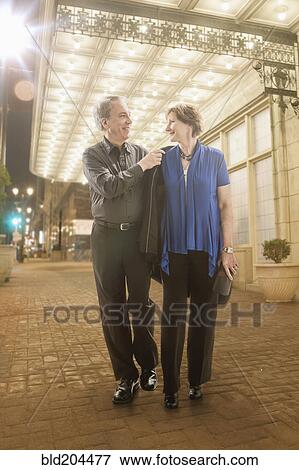 Stock Photo - Caucasian couple walking on city street. Fotosearch