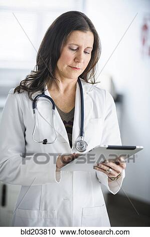 Caucasian doctor using tablet computer in office View Large Photo Image Stock Image - Caucasian doctor using tablet computer in office. Fotosearch
