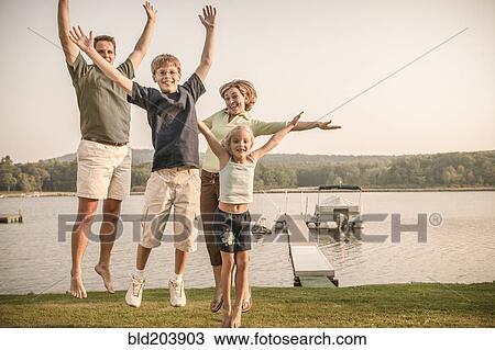 Stock Image - Caucasian family cheering in rural landscape. Fotosearch