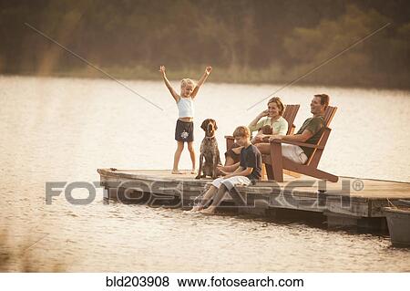 Caucasian family relaxing on pier View Large Photo Image Stock Photo - Caucasian family relaxing on pier. Fotosearch