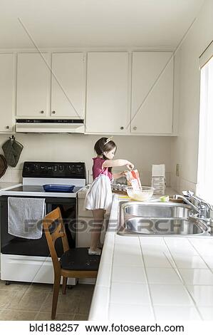 Caucasian girl baking in kitchen View Large Photo Image Stock Photo - Caucasian girl baking in kitchen. Fotosearch
