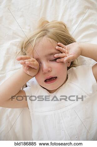 Stock Photography - Caucasian girl crying on bed. Fotosearch