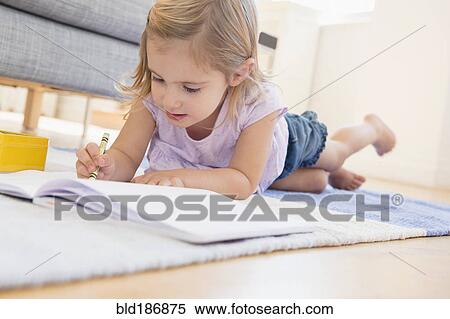 Stock Photography - Caucasian girl doodling on floor. Fotosearch
