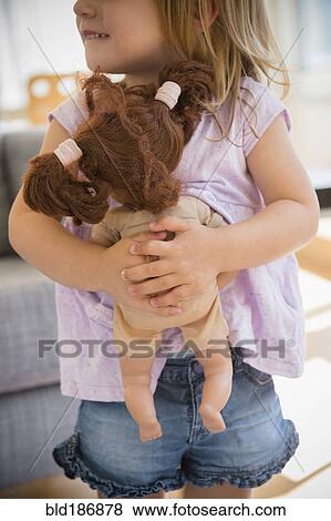 Stock Photo - Caucasian girl hugging doll. Fotosearch