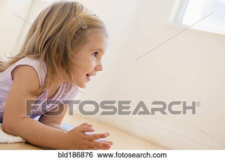Stock Photograph - Caucasian girl laying on floor. Fotosearch