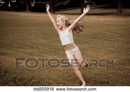 Stock Photo - Caucasian girl playing in grassy field. Fotosearch