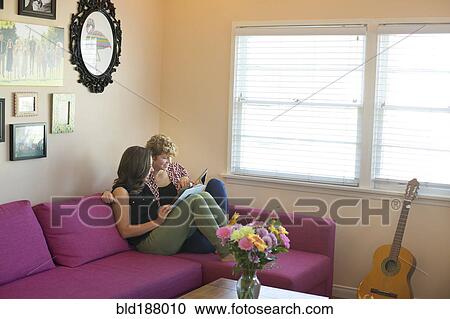 Caucasian lesbian couple reading book on sofa View Large Photo Image Stock Image - Caucasian lesbian couple reading book on sofa. Fotosearch