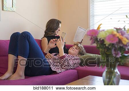 Caucasian lesbian couple using technology on sofa View Large Photo Image Stock Image - Caucasian lesbian couple using technology on sofa. Fotosearch