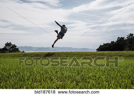 Stock Photo - Caucasian man dancing in field. Fotosearch