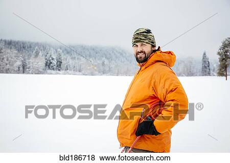Stock Photo - Caucasian man standing in snowy field. Fotosearch