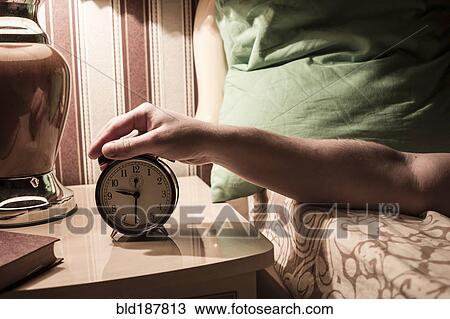 Caucasian man turning off alarm clock View Large Photo Image Stock Image - Caucasian man turning off alarm clock. Fotosearch