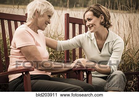 Stock Image - Caucasian mother and daughter talking outdoors. Fotosearch