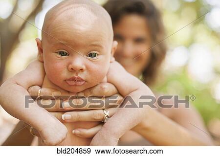 Caucasian mother holding baby outdoors View Large Photo Image Stock Photo - Caucasian mother holding baby outdoors. Fotosearch