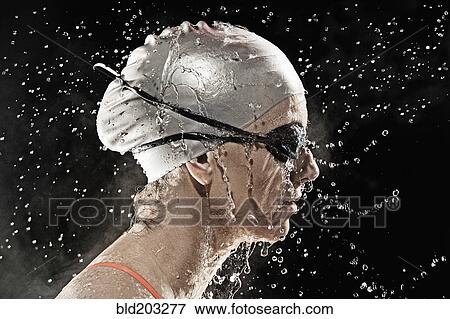 Stock Photo - Caucasian swimmer standing in rain. Fotosearch