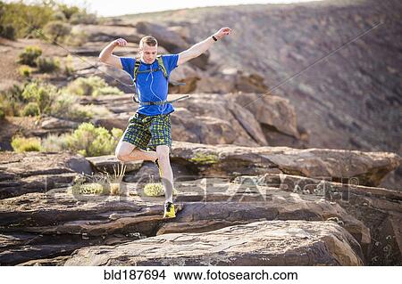 Caucasian teenage boy running on rock formation View Large Photo Image Picture - Caucasian teenage boy running on rock formation. Fotosearch