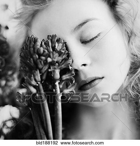 Stock Image - Caucasian teenage girl holding flower. Fotosearch