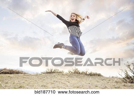 Stock Image - Caucasian teenage girl jumping for joy. Fotosearch