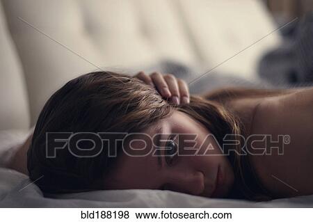 Stock Photo - Caucasian teenage girl laying on bed. Fotosearch