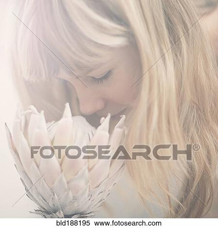 Stock Photography - Caucasian teenage girl smelling flower. Fotosearch