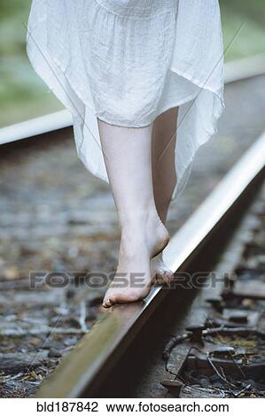 Caucasian woman balancing on train tracks View Large Photo Image Stock Image - Caucasian woman balancing on train tracks. Fotosearch