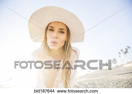 Caucasian woman blowing kiss on beach View Large Photo Image Picture - Caucasian woman blowing kiss on beach. Fotosearch