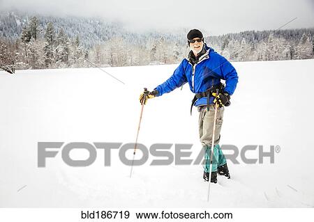 Stock Photo - Caucasian woman cross-country skiing in snowy field. Fotosearch