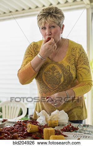 Stock Photograph - Caucasian woman eating at crawfish boil. Fotosearch