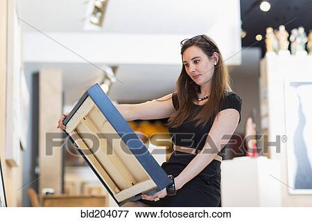 Caucasian woman examining painting in art gallery View Large Photo Image Stock Photo - Caucasian woman examining painting in art gallery. Fotosearch