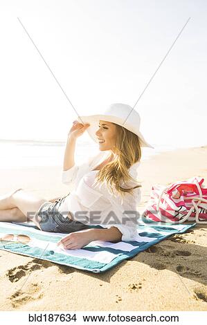 Picture - Caucasian woman laying on beach. Fotosearch