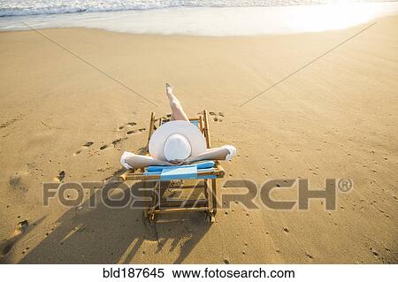Stock Photography - Caucasian woman laying on beach. Fotosearch