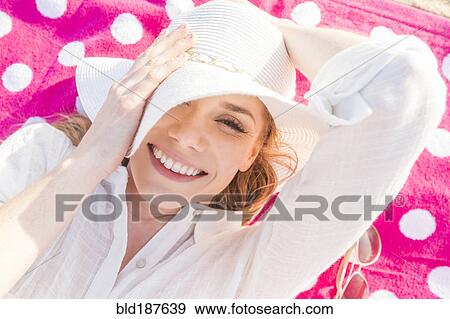 Caucasian woman laying on towel View Large Photo Image Stock Photo - Caucasian woman laying on towel. Fotosearch