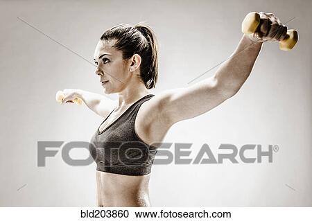 Stock Image - Caucasian woman lifting weights. Fotosearch