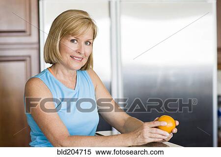 Caucasian woman peeling fruit in kitchen View Large Photo Image Stock Photography - Caucasian woman peeling fruit in kitchen. Fotosearch