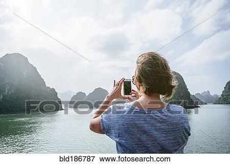 Caucasian woman photographing rock formations in Ha Long Bay, Vietnam View Large Photo Image Stock Photo - Caucasian woman photographing rock formations in Ha Long Bay, Vietnam. Fotosearch