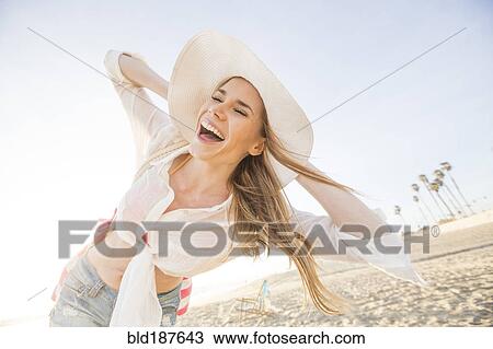 Stock Image - Caucasian woman playing on beach. Fotosearch