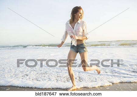 Stock Photo - Caucasian woman playing on beach. Fotosearch
