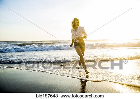 Stock Photo - Caucasian woman playing on beach. Fotosearch
