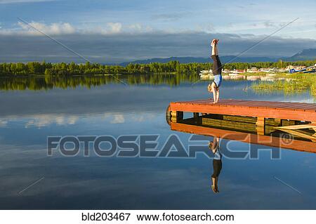 Caucasian woman practicing yoga on dock on still lake, Anchorage, Alaska, United States View Large Photo Image Stock Photo - Caucasian woman practicing yoga on dock on still lake, Anchorage, Alaska, United States. Fotosearch
