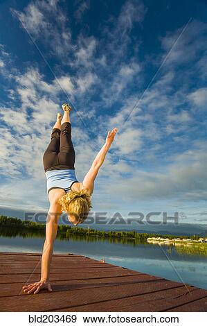Caucasian woman practicing yoga on dock on still lake, Anchorage, Alaska, United States View Large Photo Image Stock Photo - Caucasian woman practicing yoga on dock on still lake, Anchorage, Alaska, United States. Fotosearch