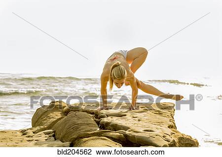 Caucasian woman practicing yoga on rocky beach View Large Photo Image Stock Image - Caucasian woman practicing yoga on rocky beach. Fotosearch