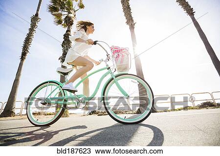 Stock Image - Caucasian woman riding bicycle. Fotosearch
