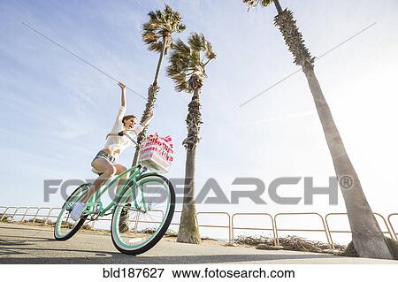 Stock Photo - Caucasian woman riding bicycle. Fotosearch
