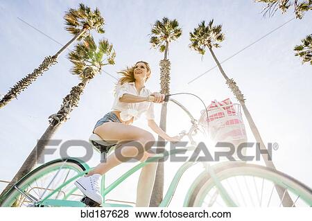 Stock Photo - Caucasian woman riding bicycle. Fotosearch