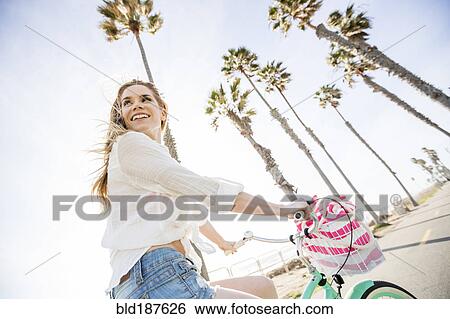 Caucasian woman riding bicycle View Large Photo Image Stock Photograph - Caucasian woman riding bicycle. Fotosearch