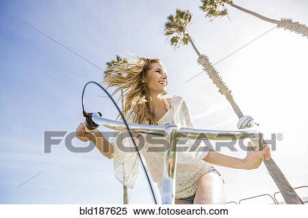 Stock Photography - Caucasian woman riding bicycle. Fotosearch