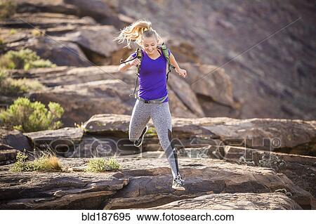 Caucasian woman running on rock formation View Large Photo Image Stock Photography - Caucasian woman running on rock formation. Fotosearch